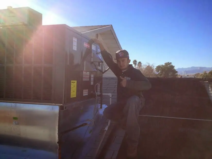HVAC technician performing HVAC Inspection on a rooftop unit in White
